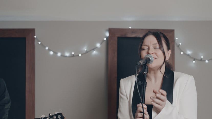 Anna singing beneath a string of fairy lights