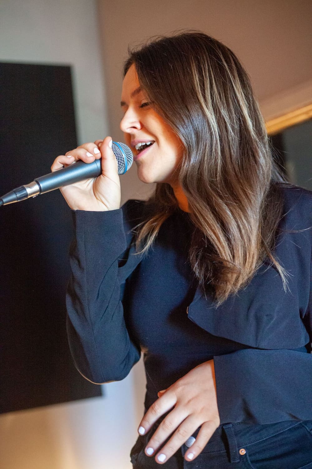 Anna singing into a microphone in the studio